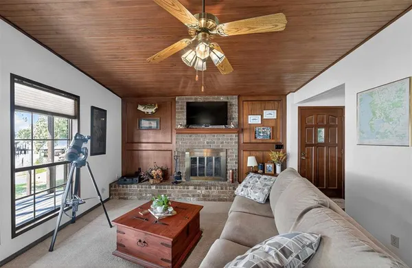 a living room with furniture a fireplace and a chandelier