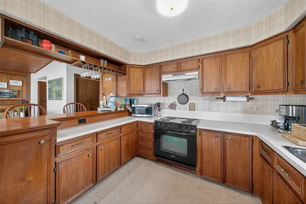 a kitchen with stainless steel appliances granite countertop a sink stove and cabinets