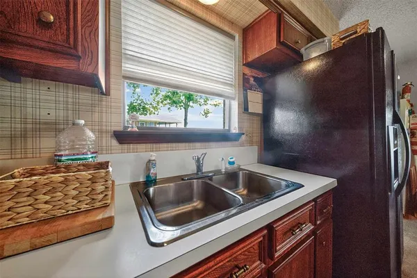 a open kitchen with stainless steel appliances granite countertop a stove top oven a sink dishwasher and a fireplace with wooden floor