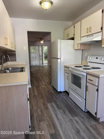a kitchen with a stove a refrigerator and a sink