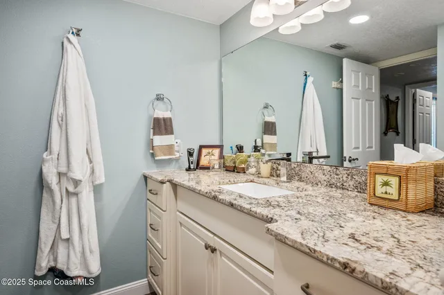 a very nice looking kitchen with granite countertop a sink cabinets and wooden floor