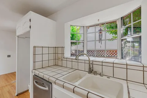 a kitchen with stainless steel appliances granite countertop a stove a refrigerator and a wooden floor