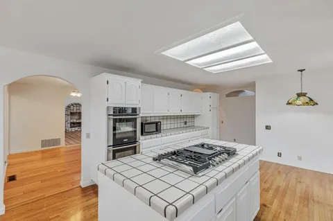 a kitchen with stainless steel appliances granite countertop a stove a sink and a microwave