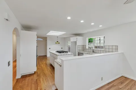 a kitchen with kitchen island a stove a sink and a refrigerator