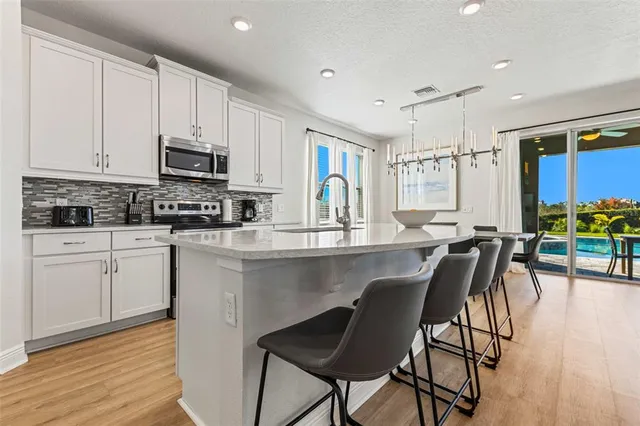 a kitchen with stainless steel appliances granite countertop a sink and white cabinets