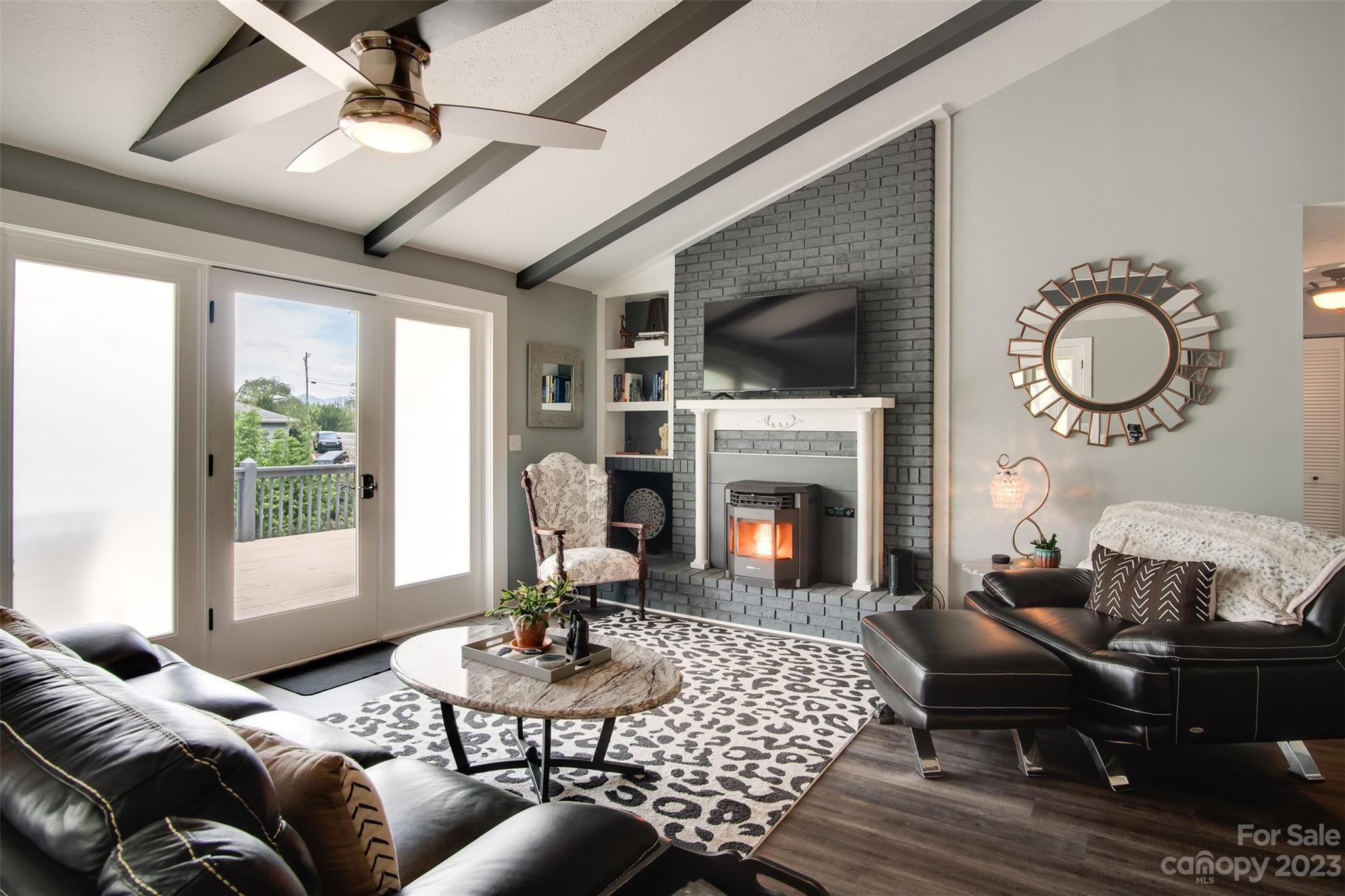 209 Emerald Hill Road Franklin, NC 28734 - Photo 4 of 33 a living room with furniture a fireplace and a dining table with wooden floor