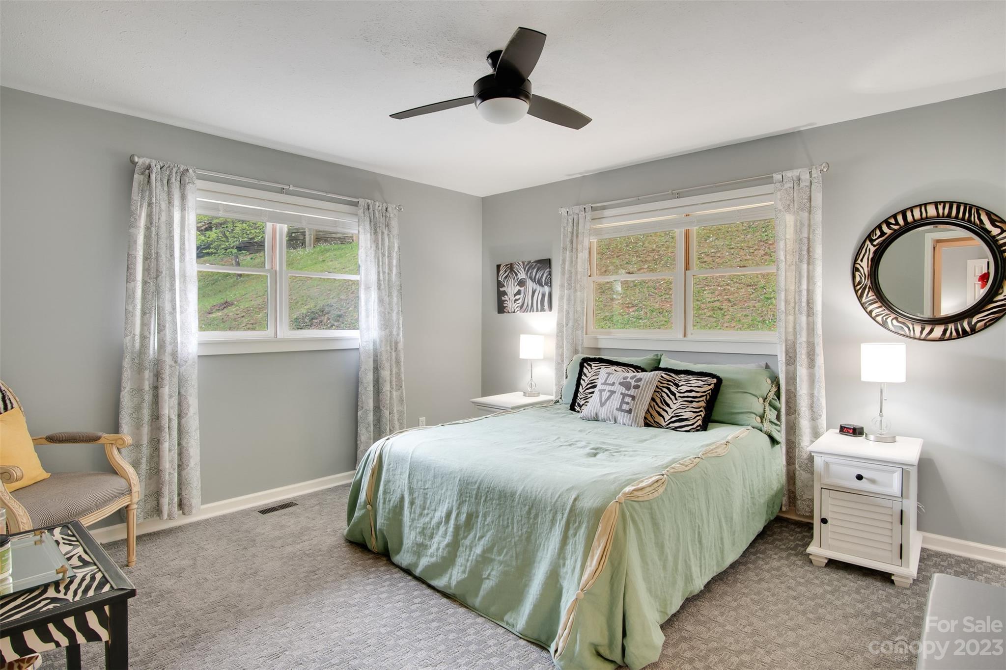 209 Emerald Hill Road Franklin, NC 28734 - Photo 8 of 33 a bedroom with a bed and a chandelier