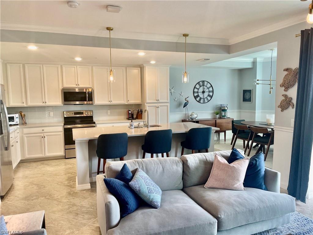 9590 Trevi Court, Unit 5337 Naples, FL 34113 - Photo 13 of 35 a living room with furniture kitchen area and a wooden floor