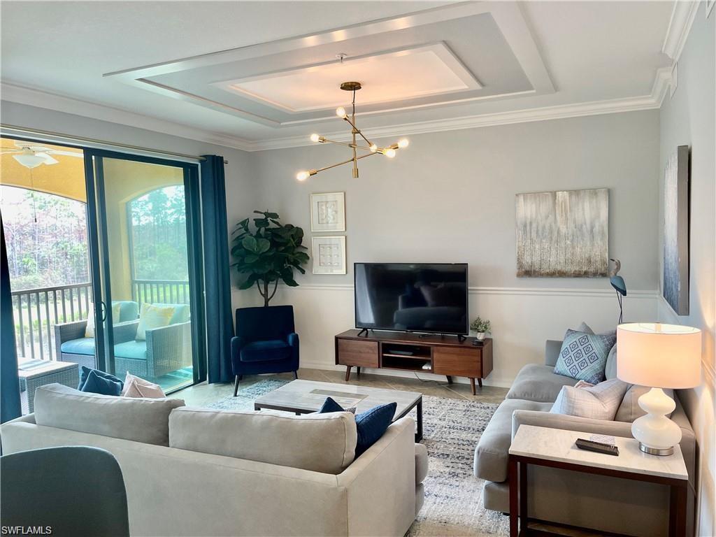 9590 Trevi Court, Unit 5337 Naples, FL 34113 - Photo 16 of 35 a living room with furniture a flat screen tv and a large window