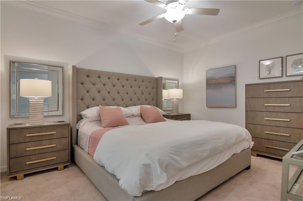9590 Trevi Court, Unit 5337 Naples, FL 34113 - Photo 17 of 35 a bedroom with a bed and a chandelier