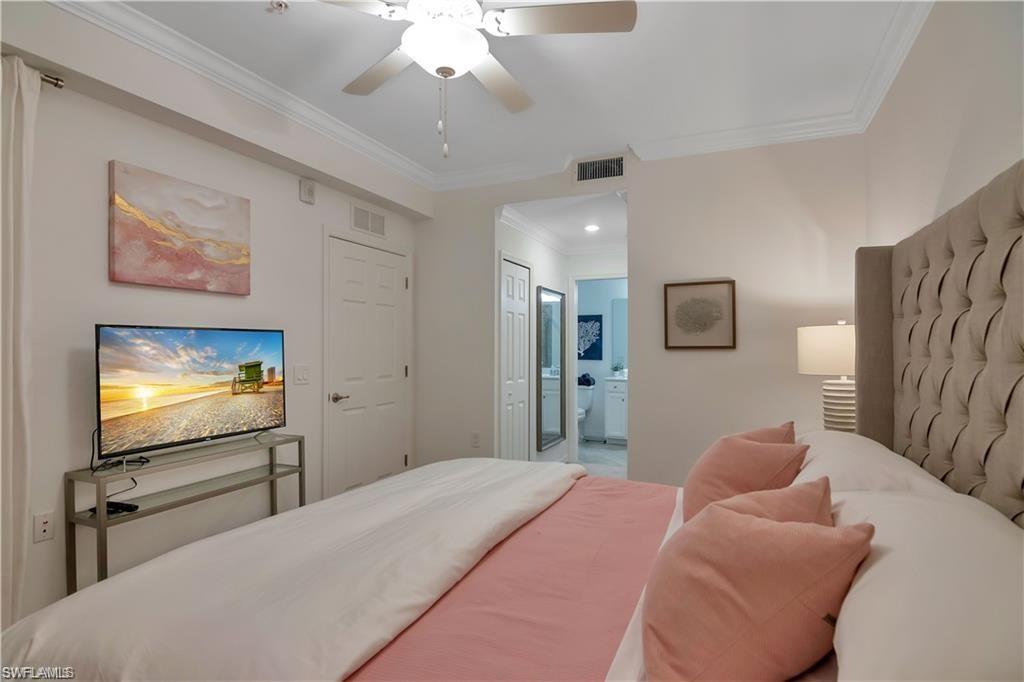9590 Trevi Court, Unit 5337 Naples, FL 34113 - Photo 18 of 35 a bedroom with a bed and a flat screen tv
