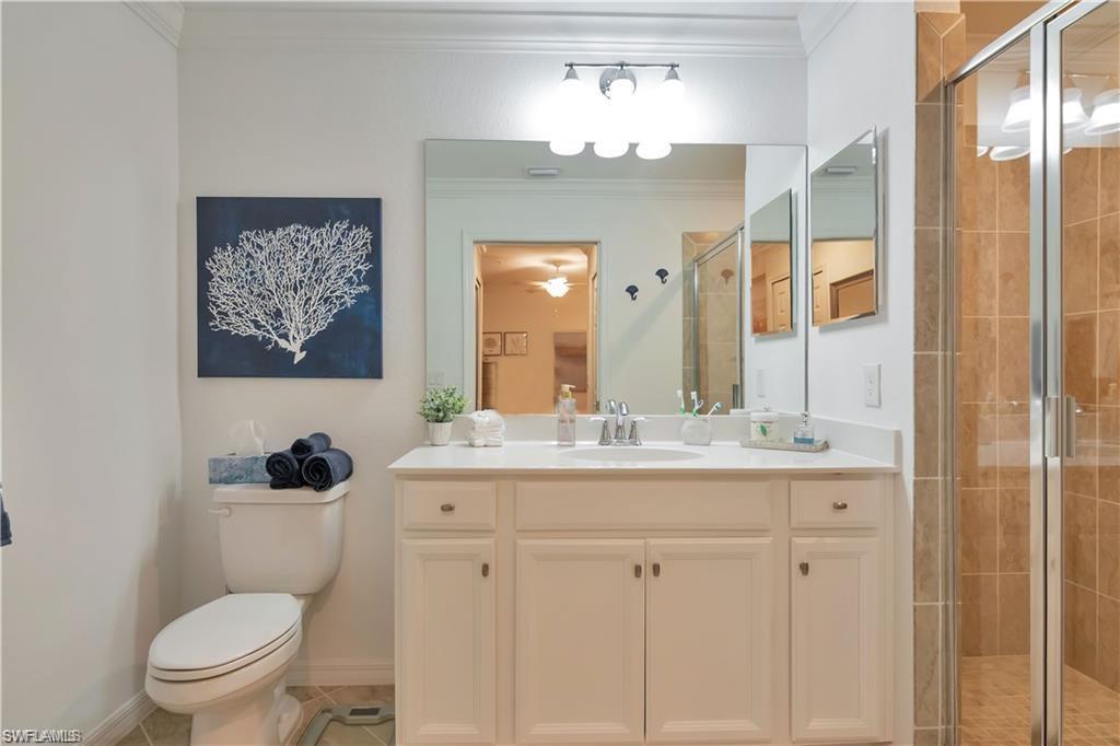 9590 Trevi Court, Unit 5337 Naples, FL 34113 - Photo 20 of 35 a bathroom with a granite countertop toilet a sink and a mirror