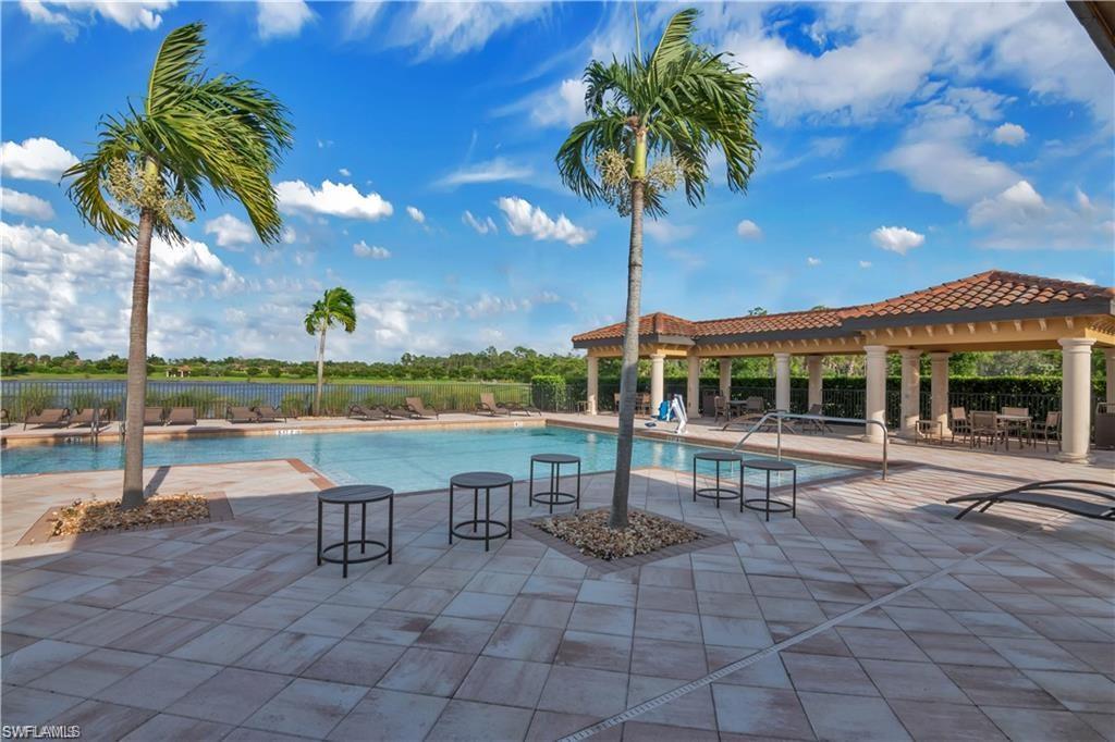 9590 Trevi Court, Unit 5337 Naples, FL 34113 - Photo 23 of 35 a view of a swimming pool with a table and chairs