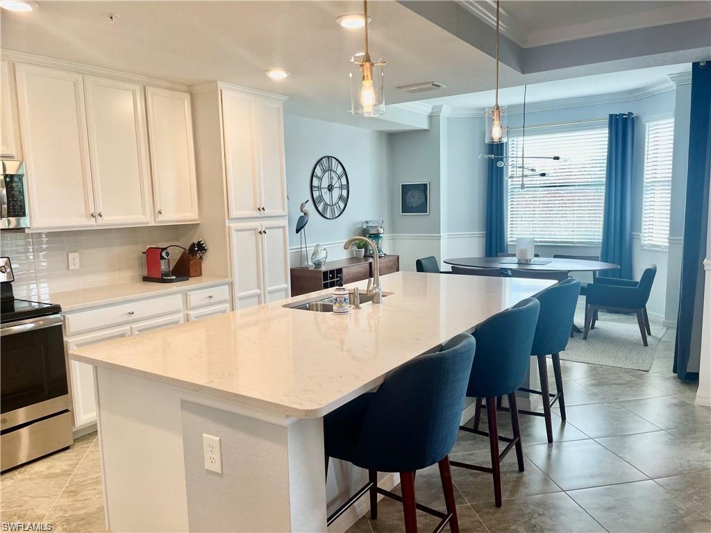 9590 Trevi Court, Unit 5337 Naples, FL 34113 - Photo 10 of 35 a kitchen with a dining table and chairs