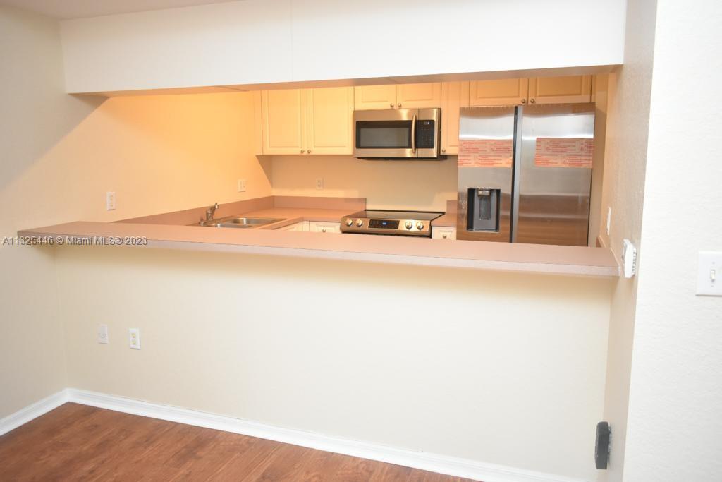 6520 West Sample Road, Unit 6520 Coral Springs, FL 33067 - Photo 11 of 33 a kitchen with a sink cabinets and a microwave