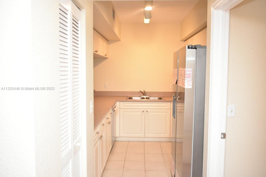 6520 West Sample Road, Unit 6520 Coral Springs, FL 33067 - Photo 13 of 33 a kitchen with a refrigerator and cabinets