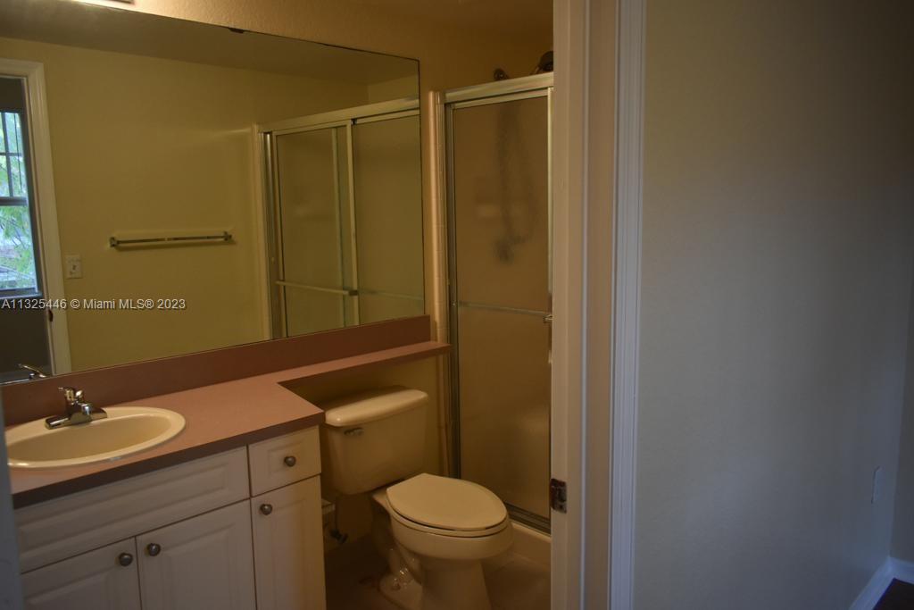 6520 West Sample Road, Unit 6520 Coral Springs, FL 33067 - Photo 28 of 33 a bathroom with a granite countertop sink toilet and shower