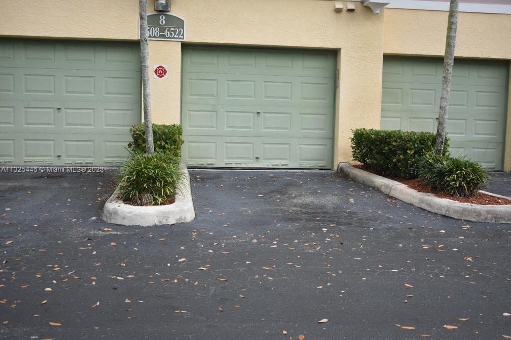 6520 West Sample Road, Unit 6520 Coral Springs, FL 33067 - Photo 29 of 33 a front view of a house with a garage