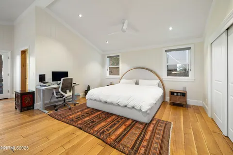 a bedroom with a bed and a flat tv screen on the dresser