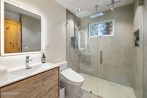 a bathroom with a granite countertop sink toilet and shower