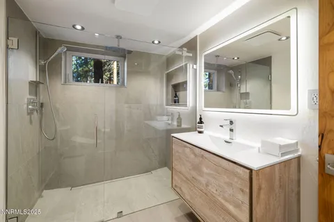 a bathroom with a sink shower and a mirror