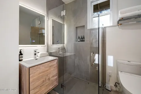 a bathroom with a sink a toilet and shower