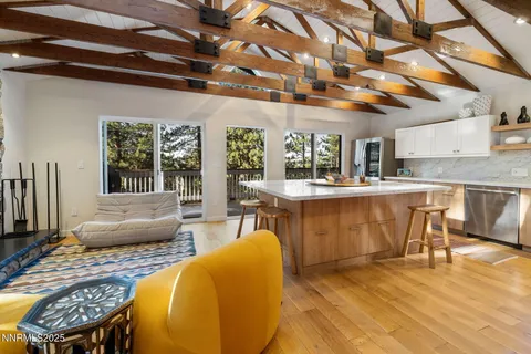 a living room with stainless steel appliances kitchen island granite countertop furniture and a large window