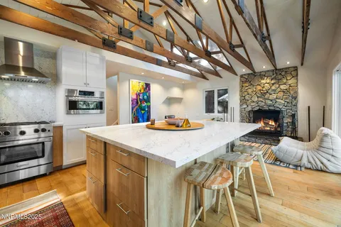 a kitchen with stainless steel appliances kitchen island granite countertop a stove a sink dishwasher and cabinets with wooden floor