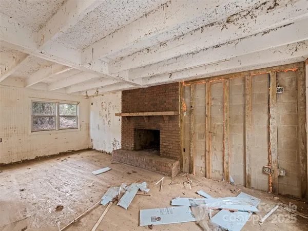 a view of a livingroom with wooden floor and a fireplace