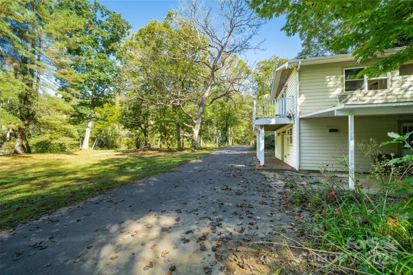 a view of a yard in front of a house with large trees