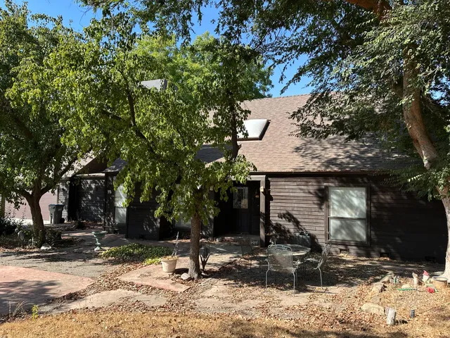 a backyard of a house with fire pit and trees