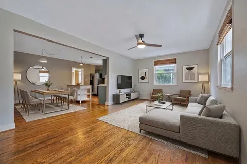 a living room with furniture a wooden floor and a chandelier