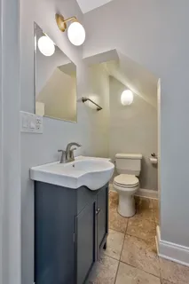 a bathroom with a toilet sink and mirror