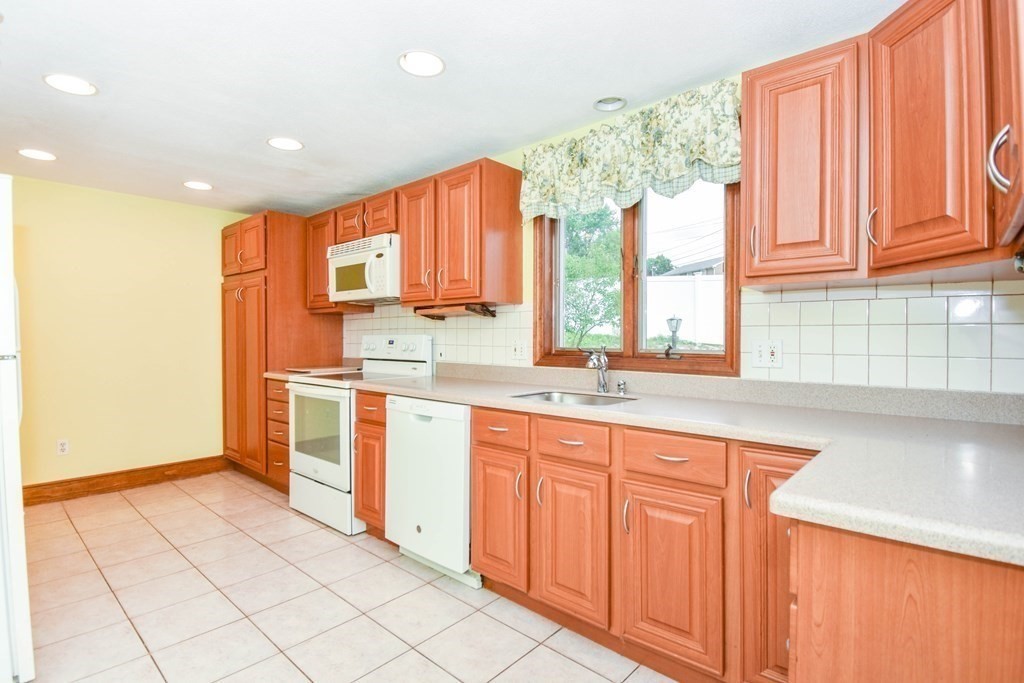 34 Farnum Road Waltham, MA 02453 - Photo 9 of 29 a kitchen with stainless steel appliances granite countertop a stove a sink and a microwave