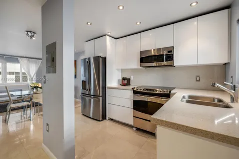 a kitchen with stainless steel appliances granite countertop a refrigerator sink and stove