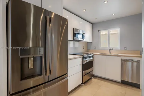 a kitchen with stainless steel appliances granite countertop a refrigerator and a sink
