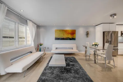 a spacious bedroom with a bed a couch and large window