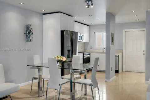 a dining room with furniture and a refrigerator