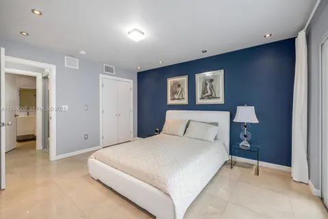 a spacious bedroom with a bed and a lamp