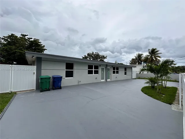 view of a house with a yard and a car parked