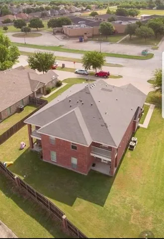 an aerial view of a house with a yard