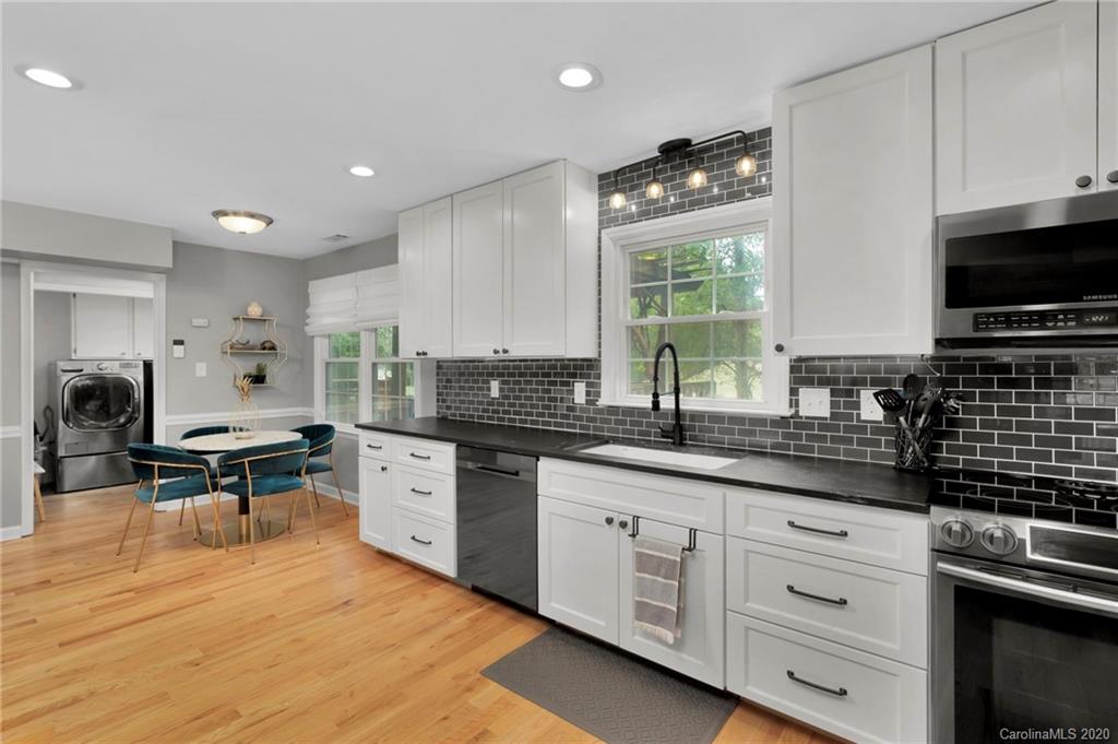 7101 Graburn Road Charlotte, NC 28226 - Photo 14 of 25 a kitchen with granite countertop a stove a sink dishwasher and a microwave oven with white cabinets