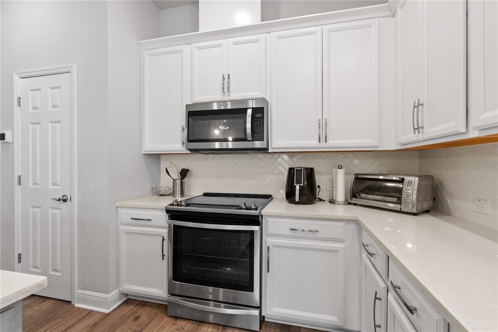 16409 Lucia Gardens Lane Tampa, FL 33625 - Photo 11 of 48 a kitchen with stainless steel appliances granite countertop grey cabinets a stove a sink and dishwasher
