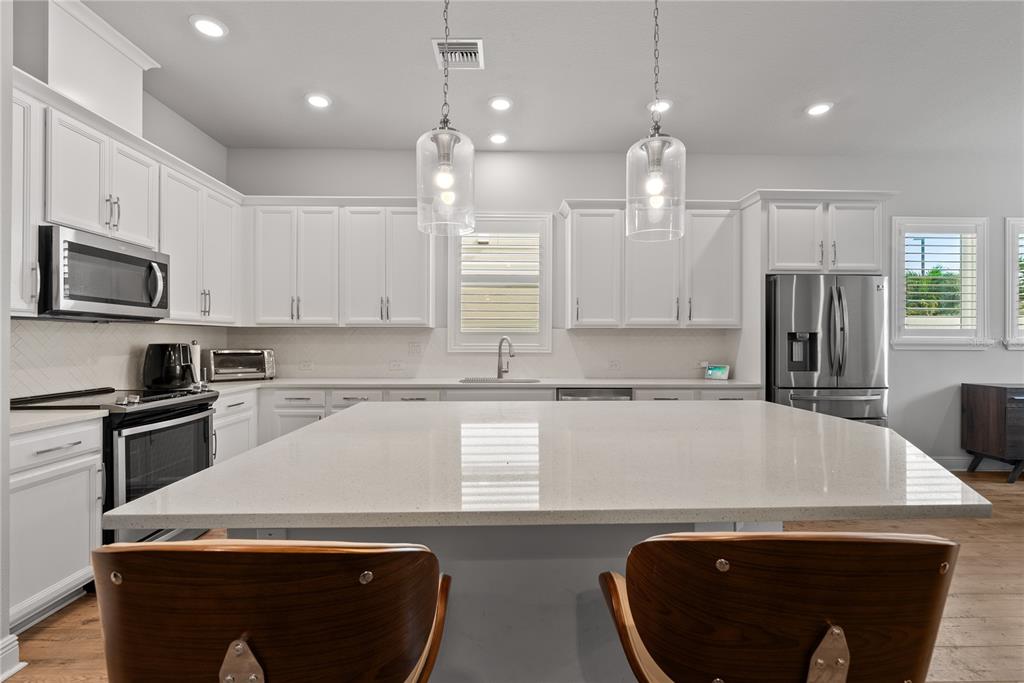16409 Lucia Gardens Lane Tampa, FL 33625 - Photo 12 of 48 a kitchen with a sink a microwave a stove and refrigerator
