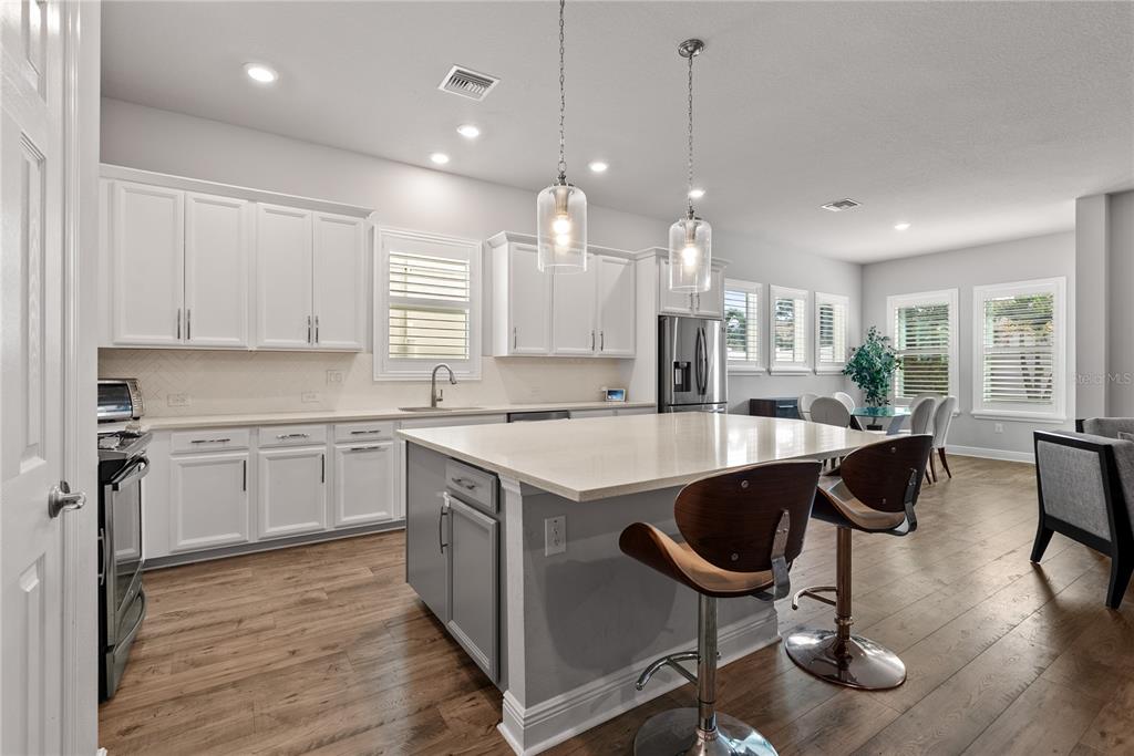16409 Lucia Gardens Lane Tampa, FL 33625 - Photo 8 of 48 a kitchen with stainless steel appliances granite countertop a sink a stove a refrigerator and island with wooden floor