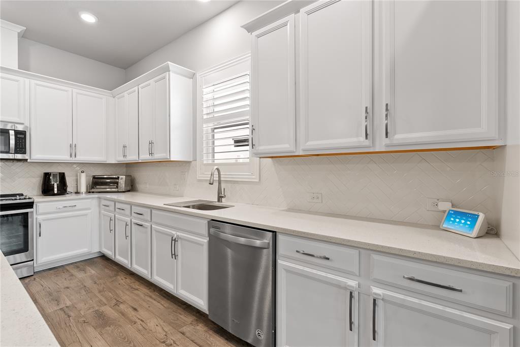 16409 Lucia Gardens Lane Tampa, FL 33625 - Photo 10 of 48 a kitchen with cabinets appliances a sink and a window