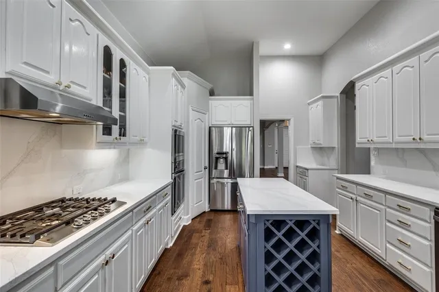a kitchen with stainless steel appliances granite countertop a stove and a refrigerator