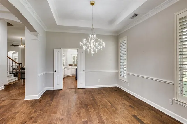 a view of a room with wooden floor and chandelier