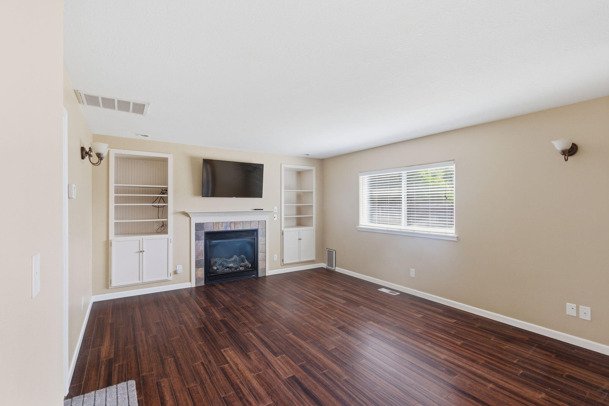 196 Nadine Lane Central Point, OR 97502 - Photo 4 of 54 an empty room with wooden floor fireplace and windows
