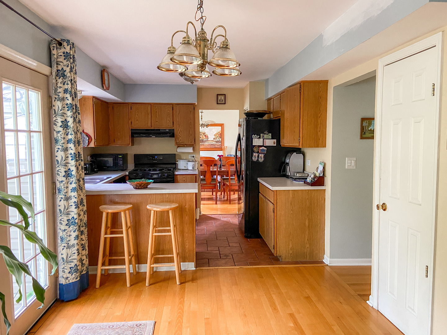 233 Dickens Trail Elgin, IL 60120 - Photo 4 of 18 a kitchen with stainless steel appliances kitchen island granite countertop a stove a refrigerator a sink a dining table and chairs with wooden floor